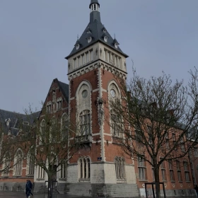 Façade d'un bâtiment historique en briques rouges avec une architecture typique et des lucarnes dans le Brabant wallon.