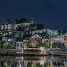 Vue panoramique de la Citadelle de Namur surplombant la Meuse et les toits des bâtiments en contrebas.
