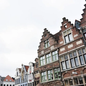 Façades de maisons traditionnelles belges à pignons à gradins sous un ciel couvert à Waterloo.